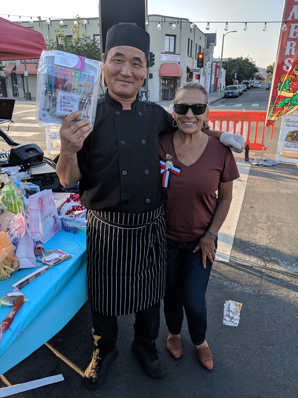 Chef vendor posing with a community member on N Broadway at the Lincoln Heights Farmers Market